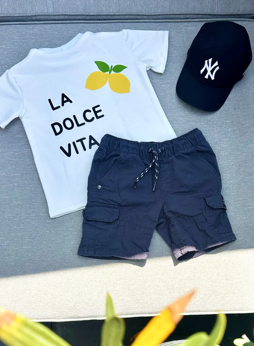 Kinder-T-Shirt in Weiß mit dem Schriftzug "La Dolce Vita" auf dem Rücken.